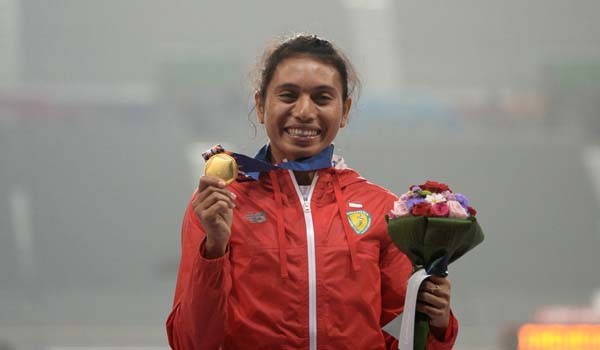 Maria Natalia Londa pose dengan medali emas Asian Games 2014. Foto: Manan Vatsyayana/AFP