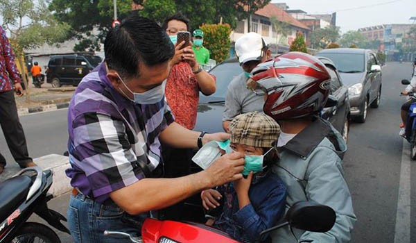 Walikota Jambi SY Fasha memakaikan masker kepada pengguna jalan