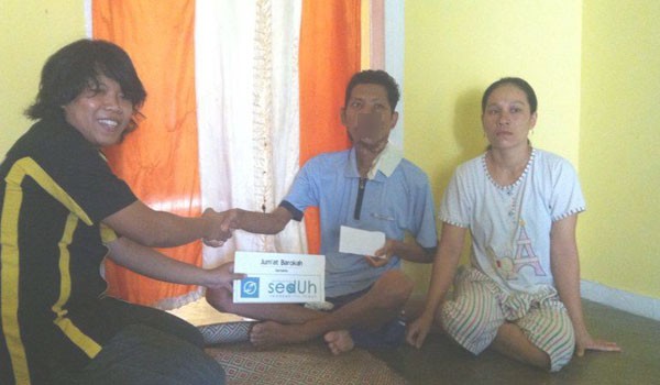 SERAHKAN BANTUAN: Salah seorang anggota Komunitas Sedekah itu Indah (Seduh) saat memberikan donasi kepada salah satu warga Kota Jambi, YUNITA/JE