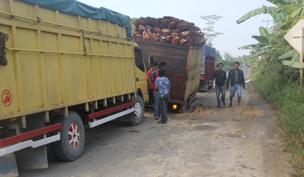 <b>Foto:</b> Truk pengangkut harus mengantri dan berhati-hati saat melewati jalan rusak di Parit IV Bram Itam tanjabbar   