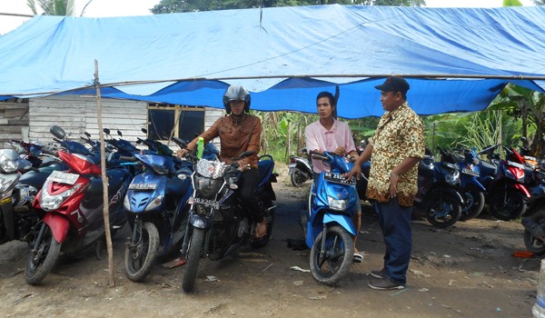 PENITIPAN : Dimaz bersama temannya secara bergantian menjaga kendaraan yang dititipkan warga, AZUL/JE         