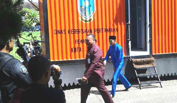 Camat pelayangan Nofriansyah berjalan mengenakan pakaian warna biru