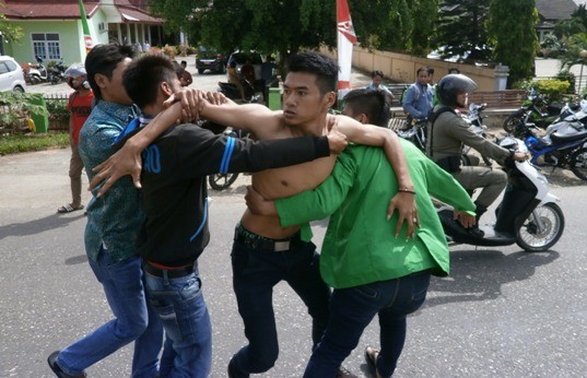 Salah seorang mahasiswa yang mengamuk ditenangkan oleh rekan-rekannya