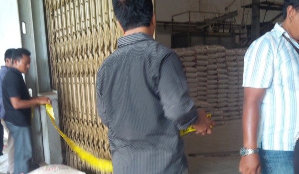 Polisi saat memasang garis polisi digudang beras milik PT Sejahtera Jambi