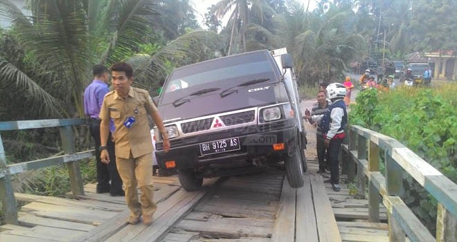 Kendaraan pengangkut air minum kemasan yang terperosok di jembatan Teluk Serdang.