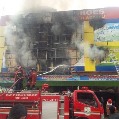 Petugas yang terus berusaha memadamkan api