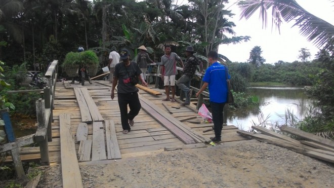 Warga saat melakukan perbaikan jembatan Teluk Serdang