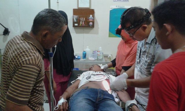 Budi Saputra (18) saat mendapatkan perawatan di Puskesmas Nipah Panjang setelah ditikam ayah tirinya tadi malam (2/12).