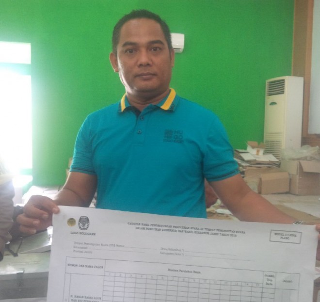 Komisioner KPU Kota Jambii Abdul Rahim memperlihatkantempelan hologram warna kuning emas berbentuk bulat yang ditempel di logo KPU pada C1 dan Plano 