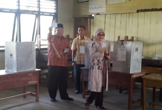 Cabup Tanjab Barat Safrial MS di dampingi istri Cici Halimah menyalurkan hak pilih di TPS 07 Kelurahan Tungkal II, Tungkal Ilir Rabu (9/12)