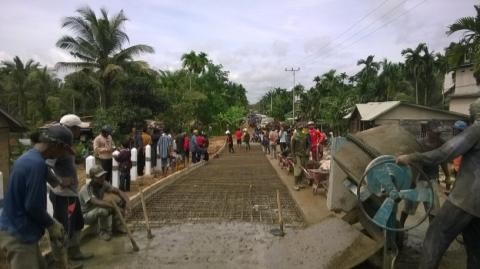 Badan jembatan yang menutupi jalan desa, memaksa pengguna jalan melewati pekarangan rumah warga.