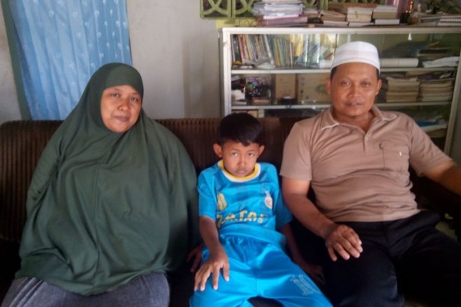 Ridho bersama kedua orang tuanya saat dijumpai di kediamannya.