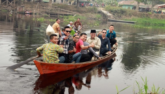 IW harus menaiki sampan menyeberangi sungai untuk bisa menemui masyarakat di Desa Sponjen, Kumpeh. 