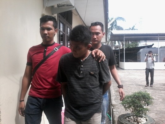 Ucok saat digelandang anggota Polisi di Mapolresta Jambi, Kamis (21/1).