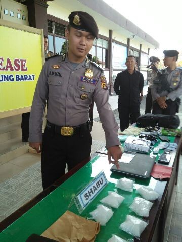 Salah satu anggota polisi menunjukkan barang bukti sabu yang diamankan dari tersangka Roni