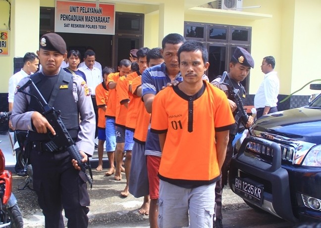 Para pelaku saat digiring petugas dengan senjata laras panjang di Mapolres Tebo, Minggu (7/3).