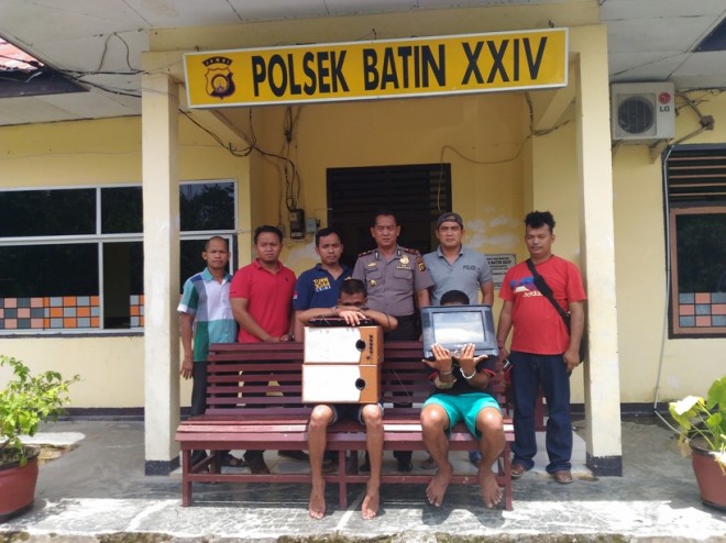 Dua tersangka memegang barang bukti saat diamankan di Mapolsek Bathin XXIV