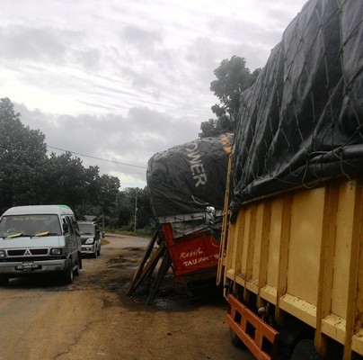 Kerusakan jalan di dekat kantor Lurah Parit Culum I, yang menyebabkan truk pengangkut sawit terperosok.