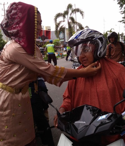 Salah satu Polwan di Merangin saat membagikan bingkisan kepada pengguna jalan yang taat peraturan lalu lintas.