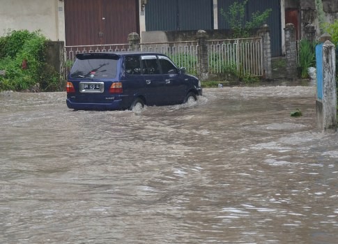 Warga Kota Jambi menerobos banjir di ruas Jalan Dara Jingga, Senin (25/4).