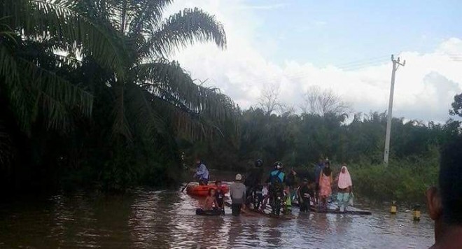 Warga menggunakan rakit untuk melintas di ruas jalan menuju ke Kota Muara Bulian Minggu (1/5)