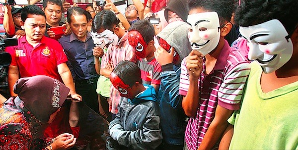 Wali Kota Surabaya, Tri Rismaharini (kiri) mendengarkan keterangan MI, salah satu pelaku yang masih SD, di Mapolrestabes Surabaya kemarin. Tiga di antara delapan pelaku masih duduk di bangku SD dan lima lainnya siswa SMP. FOTO: AHMAD KHUSAINI/JAWA POS
