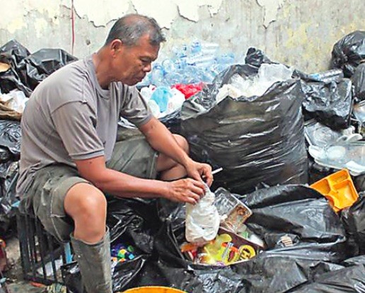 BAHRUL MARZUKI/JAWA POS RADAR MALANG MASIH ADA YANG JUJUR: Bripka Seladi memilah sampah di gudang rongsokannya. FOTO: JAWA POS GROUP