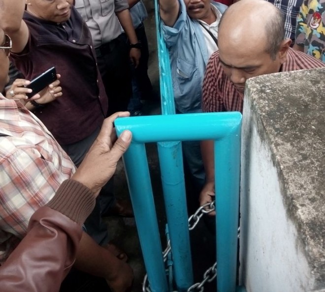 Anggota DPRD Kota Jambi Abdullah Somad menggembok kantor Disdik Kota Jambi siang ini (20/7)