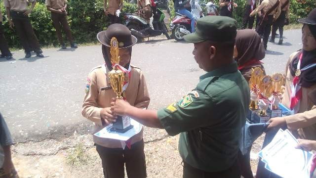 Anggota Babinsa saat menyerahkan pemenang lomba gerak jalan pramuka se Kecamatan Danau Teluk.
