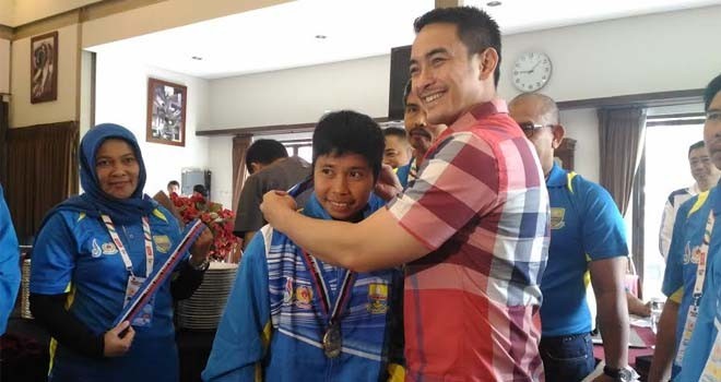 Gubernur Jambi Zumi Zola memberikan medali PON pertama.