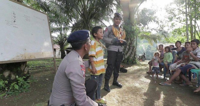 Terlihat Anggota Brimobda Jambi tengah mengajar Anak-anak SAD di Kebun Sawit.