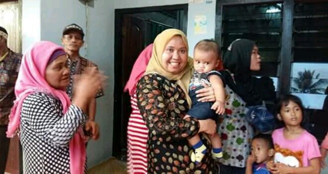 Masnah Busro saat menggendong bayi warga Muarojambi saat melakukan kunjungan dan dialog bersama masyarakat Muarojambi.