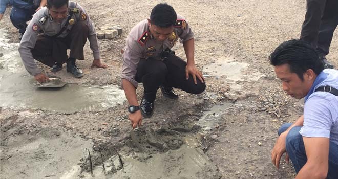 Kapolsek Pasar, Kompol Ridwan Hutagol saat melakukan kegiatan sosial dengan menyemen jalan berlobang.