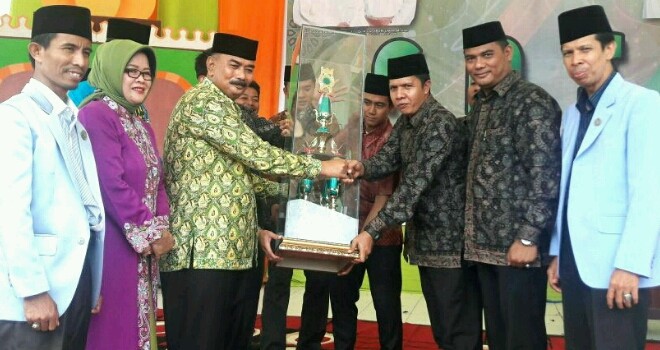 Wabup Tanjab Barat, Amir Sakib menyerahkan Tropy Juara Umum kepada Kabag Kesra Kota Jambi M. Shaleh Ridha.
