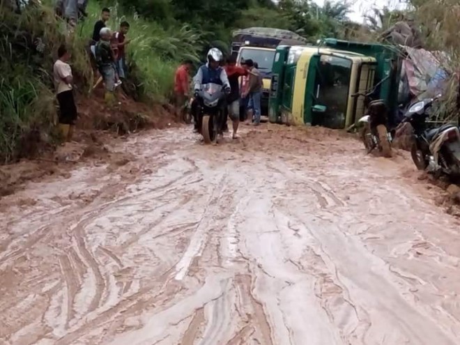 Longsoran tebing yang menutup badan jalan membuat sebuah mobil terbalik di ruas jalan Bangko-Jangkat