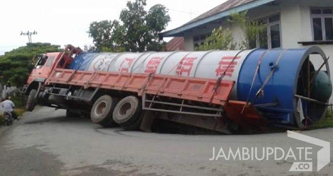 Terlihat mobil tronton yang terperosok.