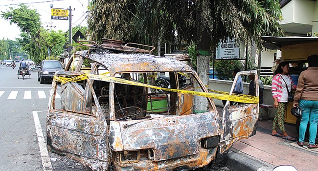 Mobil angkutan umum jurusan Kediriâ€“Pare yang terbakar di pinggir jalan depan Fasilitas Kesehatan (Faskes) Polsek Kediri Kota hanya menyisakan kerangka. Foto : M. Fikri Zulfikar/Radar Kediri/JPG 