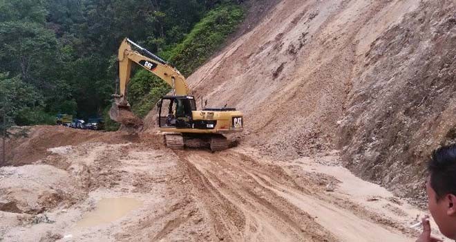 Terlihat satu unit excavator berupaya membuka akses jalan yang terputus akibat longsor.