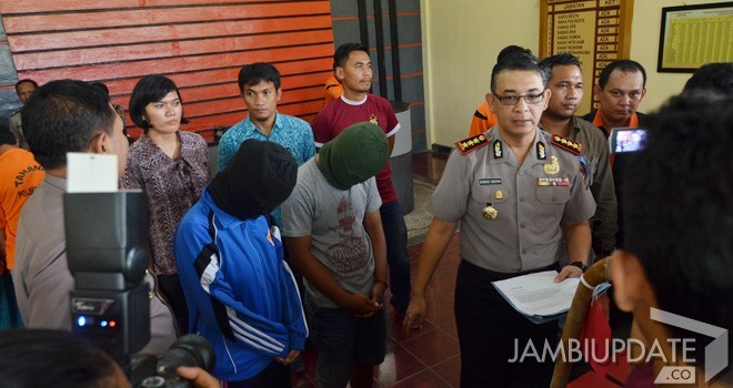 Aparat kepolisian saat menemukan janin berusia 5 bulan hasil hubungan gelap. Kedua tersangka menutup wajah saat diamankan di Mapolresta Jambi kemarin (18/11). Foto : M Ridwan / Jambi Ekspres 