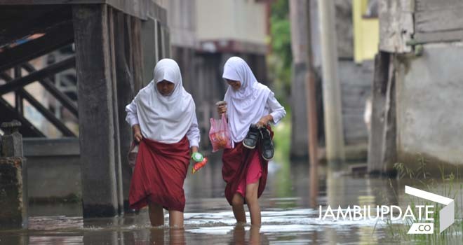 Siswa di Seberang Kota Jambi menerobos banjir ketika berangkat ke sekolah. Foto : M.Ridwan/Jameks