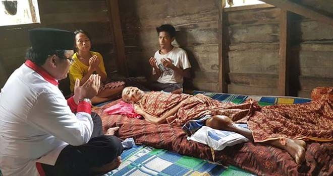 Terlihat Ivan Wirata (IW) sedang mendoakan warga yang sedang sakit.