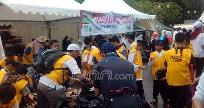 Relawan Aksi Bela Islam III dari Ar rahman Quranic Learning (AQL) Center saat membersihkan kawasan Monas dari sampah. Foto Fandi Permana/jpnn.com