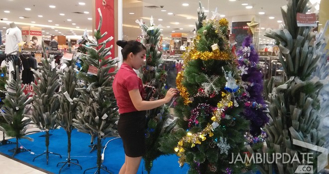Pegawai Mall Jambi Town Squer sedang merapikan pohon-pohon natal yang dipajang sebelum puncak natal. 