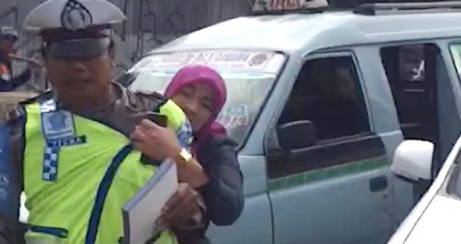 Dora Natalia (berjilbab) saat mengamuk Aiptu Sutisna di Jalan Jatinegara Barat, Selasa (13/12). Foto; YouTube