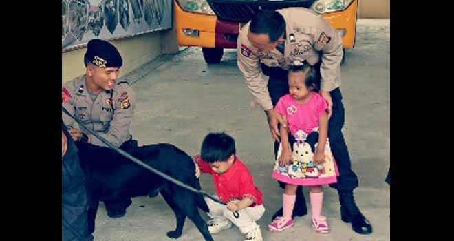 Terlihat Anak-anak lagi bermain dengan anjing pelacak.