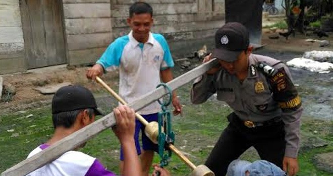 Bhabinkamtibmas Mestong saat membantu masyarakat Desa Sungai Landai.