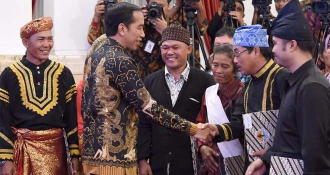 Ketua FMS, Ishak, saat menerima SK pengakuan hutan adat dari Presiden Jokowi di istana negara.