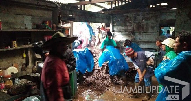 Terlihat warga gotong royong membersihkan rumah warga yang tertimbun longsor.