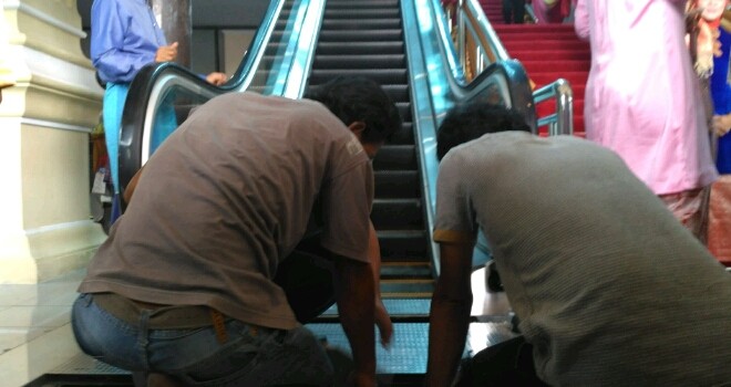 Terlihat petugas tengah memperbaiki eskalator di gedung dewan.