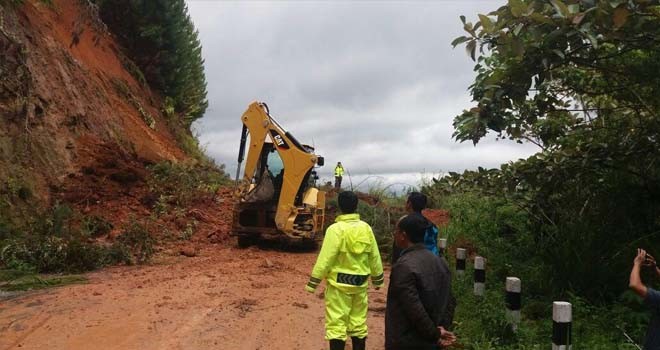 Alat berat yang diturunkan mmebersihkan material longsor.